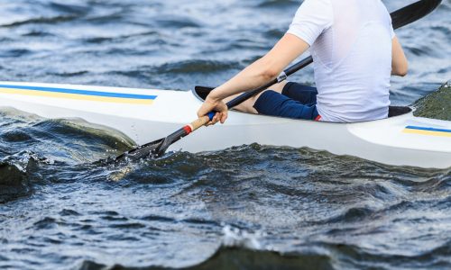 closeup of an athlete in a canoe holding a paddle